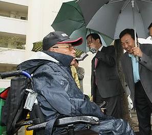 ▲ 손학규 전 대표가 민주당 후보의 당선을 위해 악천 후에도 거리 지원유세를 강행하고 있다. 손 전 대표는 이날 인천부평을에 이어 시흥정왕동 5일장터에서도 비를 맞으며 선거유세를 했다. 사진은 휠체어를 타고 있는 시민에게 한표를 호소하는 손 전 대표(우)의 모습&nbsp; ⓒ연합뉴스