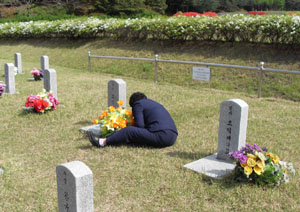 ▲ 5월 3일 대전 현충원 경찰관 묘역에서 동의대 사태로 순직한 고 모성태 수경의 어머니 최정자씨가 모 수경의 묘비를 붙잡고 통곡하고 있다. ⓒ 뉴데일리