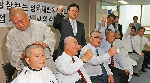 ▲ 친박연대 서청원 김노식 양정례씨가  공천헌금을 주고받은 혐의로 14일 대법원 판결에서 의원직 상실형을 받자, 당직자들은 항의의 뜻으로 삭발식을 거행하며 판결에 불만을 표했다. ⓒ 연합뉴스