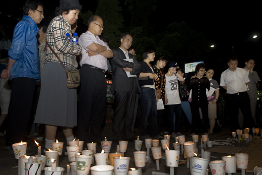 ▲ 25일 덕수궁 대한문 앞에 차려진 분향소에 조문을 나온 시민들이, 길거리 바닥에 쓰여진 이명박 대통령을 폄훼하는 문구를 읽고 생각에 잠겨있다. <사진/황문성 기자>    ⓒ 뉴데일리