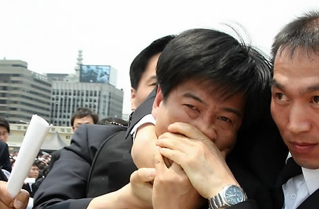 ▲ 29일 경복궁 앞뜰에서 열린 노무현 전 대통령 영결식에서 이명박 대통령이 헌화.분향을 하자 백원우 민주당 의원이 뛰어나오며 고함을 지르다 경호원들에게 제지당하고 있다. ⓒ 연합뉴스