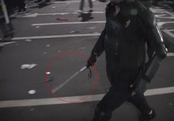 지난 10일 시위 진압에 나선 한 경찰이 20∼30㎝ 길이의 흰색 막대기를 들고 있다. 붉은 색 원 안의 막대기가 일명 '삼단봉'으로 추정되는 진압봉이다. 사진은 '칼라TV' 동영상 캡쳐.   ⓒ 뉴데일리