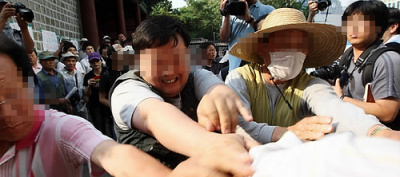 ▲ 노무현 전 대통령 분향소가 마련된 덕수궁 대한문 앞 분향소에 들어온 보수단체 회원(흰옷)을 분향소를 지키던 사람들이 집단으로 밀어내고 있다(사진은 모자이크 처리함) ⓒ 연합뉴스