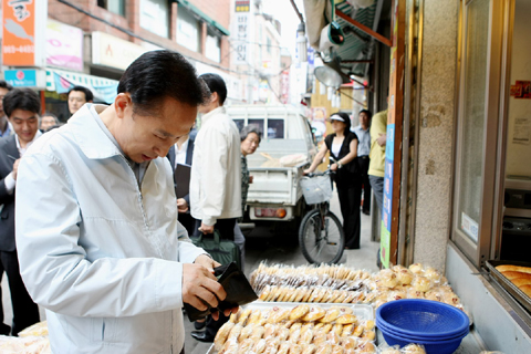 ▲ '지갑 연 대통령'. 25일 서울 이문동 한 골목상가를 방문한 이명박 대통령이 빵값을 치르기 위해 직접 지갑에서 돈을 꺼내고 있다. ⓒ 뉴데일리<=청와대 제공> 