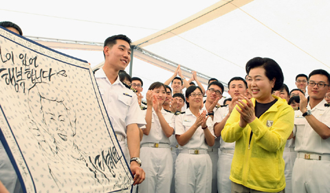 ▲ 10일(현지시간) 이탈리아 치비타베키아항에 정박 중인&nbsp;대한민국 해군 순항훈련전단 최영함과 대청함을 방문, 장병과 사관생도 격려에 나선 이명박 대통령 부인 김윤옥 여사가 장병들로부터 얼굴이 그려진 스카프를 선물받고 기뻐하고 있다. ⓒ 뉴데일리<=청와대 제공>&nbsp;
