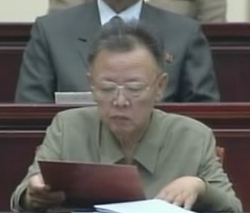 ▲ 북한 김정일이 지난 8일 평양체육관에서 열린 김일성 주석 15주기 중앙추모대회에 참석해 서류를 보고 있는 모습. 사진을 보면 김정일은 윗부분 머리카락이 많이 빠진 것이 확연히 드러나며 다소 수척해진 얼굴에 오른쪽 입꼬리가 올라간&nbsp;모습을 볼 수 있다 ⓒ 연합뉴스 <<조선중앙TV촬영>> 