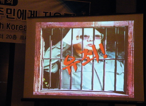 ▲ '반인도범죄조사위원회'가 준비한 북한인권유린 프레젠테이션의 마지막 페이지에서 북한 김정일 사진에 