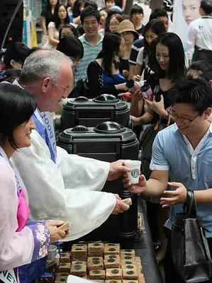 ▲ 스타벅스코리아가 국내 진출 10주년을 맞아 국내 1호점인 이대점에서 무료 커피를 나눠주고 있다. ⓒ 연합뉴스