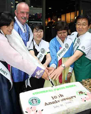 ▲ 스타벅스코리아가 국내진출 10주년을 기념해 기념 떡을 자르고 있다. 왼쪽에서 두번째가 마틴골드 스타벅스 인터내셔널 사장, 오른쪽 끝이 이석구 스타벅스코리아 대표. ⓒ 연합뉴스  