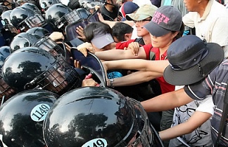 ▲ 2일 오후 쌍용차 사측이 노사 당사자간 협상의 결렬을 선언하고 물리적 공장진입 의사를 밝힌 가운데 점거 파업중이던 노조원들에게 식수를 전달하려는 시민.인권 단체 회원들이사측 용역 직원과 몸싸움을 벌이자 경찰이 개입, 회원들을 인도로 밀어내고 있다.&nbsp; ⓒ&nbsp;연합뉴스
