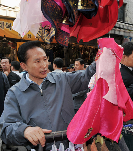 ▲ 10일 서울 남대문시장을 방문한 이명박 대통령이 한복가게에서 손녀에게 선물할 한복을 구입하고 있다. ⓒ 뉴데일리 <=청와대 제공>