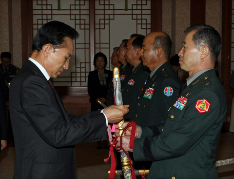 ▲ 이명박 대통령이 17일 오전 청와대에서 열린 대장 진급자 보직신고식에서 김상기 3군사령관의 삼정도에 수치를 매어주고 있다. ⓒ 뉴데일리<=청와대 제공>&nbsp;