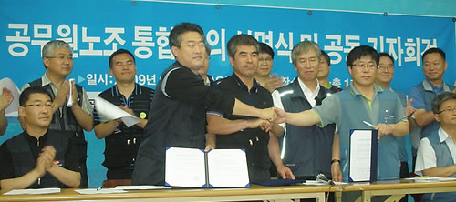 ▲ 지난 6월 전국공무원노동조합, 민주공무원노동조합, 법원공무원노동조합 등 3개 공무원 노조가 통합 합의서에 서명한 뒤 악수를 나누고 있다 ⓒ연합뉴스