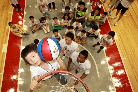 ▲ KT 소닉붐과 함께하는 희망의 농구교실에 참가한 어린이가 농구단 선수들과 함께 덩크슛하는 모습.  ⓒ 뉴데일리