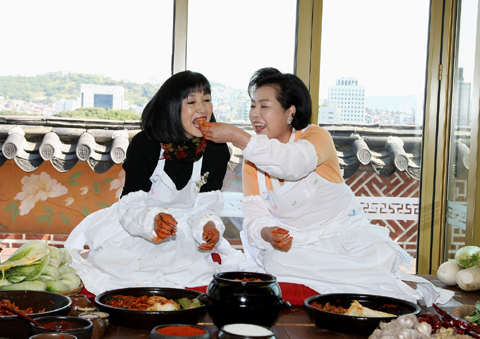 ▲ 이명박 대통령 부인 김윤옥 여사가 9일 하토야마 유키오(鳩山由紀夫) 일본 총리 부인 미유키 여사에게 직접 담근 김치를 입에 넣어주고 있다. 두 정상부인은 한국전통음식연구소에서 김치담그기 행사를 가졌다. ⓒ 뉴데일리 <=청와대 제공>