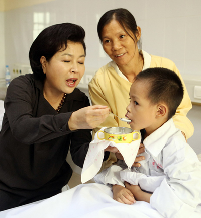 ▲ 베트남을 방문중인 이명박 대통령 부인 김윤옥 여사가 21일 하노이 시내 108국군중앙병원을 찾아 안면기형 베트남어린이에게 '타락죽'을 직접 먹여주고 있다. ⓒ 뉴데일리 <=청와대 제공>
