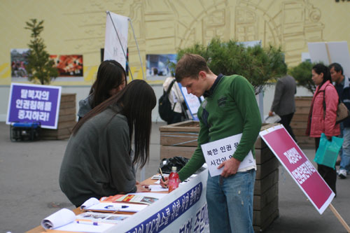 ▲ 중국의 탈북자 강제송환 중단 촉구 서명을 하는 외국인. ⓒ 뉴데일리