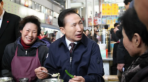 ▲ 이명박 대통령이 2일 오후 대구 서문시장을 방문해 수제비를 먹으며 시장상인들과 이야기를 나누고 있다. 이 대통령 왼쪽은 지난 2007년 대선 과정에서 이 대통령을 끌어안고 