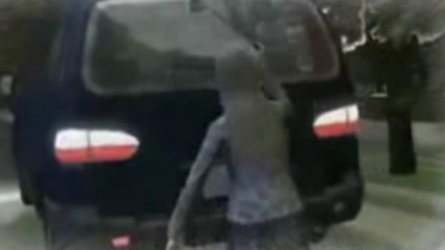 ▲ 아내에게 뺨을 맞은 우즈가 자신의 차를 몰고 집 밖을 나서자 노르데그렌이 골프채를 들고 쫓아가 차량의 뒷쪽을 내리치고 있다. ⓒ 뉴데일리