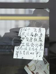 ▲ 4일 중국 북경의 중앙TV 본사 앞에서 경찰에 의해 버스로 연행된 한 시위자가 '평등과 정의를 추구한다'는 피켓을 들어 보이고 있다. ⓒ&nbsp;교도통신 제공&nbsp;