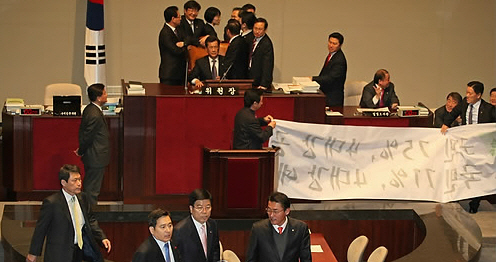 ▲ 17일 오전 국회에서 열린 예결위 전체회의에서 민주당 의원들이 위원장석을 점거하자 심재철 위원장(한나라당)이 실랑이를 벌이다 정회를 선포한 뒤 퇴장하고 있다.ⓒ 연합뉴스 
