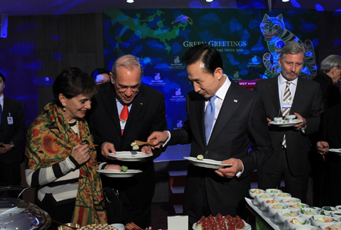 ▲ 스위스 다보스에서 개최된 '한국의 밤(Korea Night) 2010' 행사에서 이명박 대통령이 한식을 참석자들에게 직접 건네주고 있다. ⓒ 뉴데일리