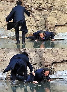 ▲ 5일 울산시 울주군 국보 반구대 암각화를 찾은 한나라당 정몽준 대표가 얼음이 깨지면서 한쪽 다리가 물에 빠져 넘어지자 김기현 의원(왼쪽)이 정 대표를 부축하고 있다. 일어서 나온 정대표가 멋쩍게 웃고 있다. ⓒ 연합뉴스