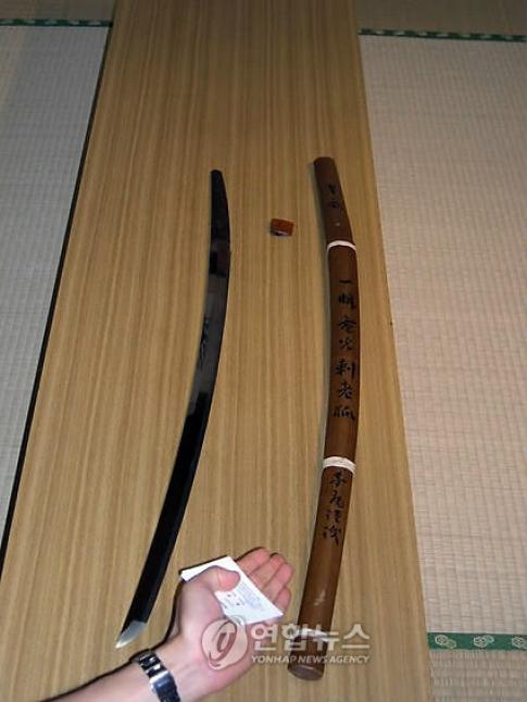 ▲ 칼 길이 120㎝, 칼날 90㎝&nbsp;히젠도.&nbsp;나무로 만든 칼집에는 '늙은 여우를 단칼에 찔렀다(一瞬電光刺老狐)'라고 새겨져 있다. 신사에서는 '황후를 이 칼로 베었다'라고 적힌 문서를 보관중이다.