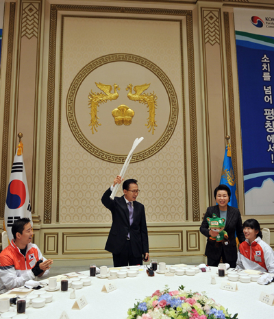 ▲ 2010 밴쿠버 장애인동계올림픽 선수단을 청와대로 초청, 격려오찬을 한 이명박 대통령 내외가 선수단으로부터 받은 선물을 흔들어보이고 있다. ⓒ 뉴데일리 <= 청와대 제공>