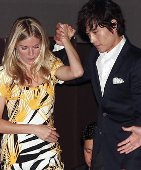 ▲ 배우 이병헌이 짧은 치마를 입은 시에나 밀러를 배려해 손을 잡고 무대에 오르고 있다. ⓒ 연합뉴스