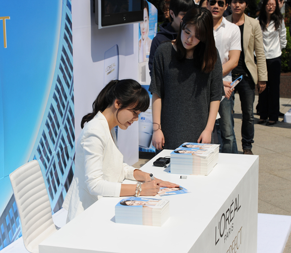 ▲ 월드스타 김윤진이&nbsp; 25일 오전 서울 소공동 롯데백화점 본점 야외광장에서 열린 유브이 퍼펙트 자외선차단제 아시아 판매 1500만개 돌파 행사에 참석, 행사장을 방문한 고객들에게 싸인을 하고 있다.&nbsp;ⓒ 박지현 기자