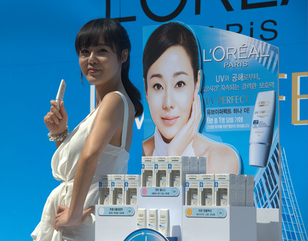 ▲ 월드스타 김윤진이 25일 오전 서울 소공동 롯데백화점 본점 야외광장에서 열린 유브이 퍼펙트 자외선차단제 아시아 판매 1500만개 돌파 행사에 참여, 유브이 퍼펙트 제품을 들고 포즈를 취하고 있다. ⓒ&nbsp;박지현 기자&nbsp;