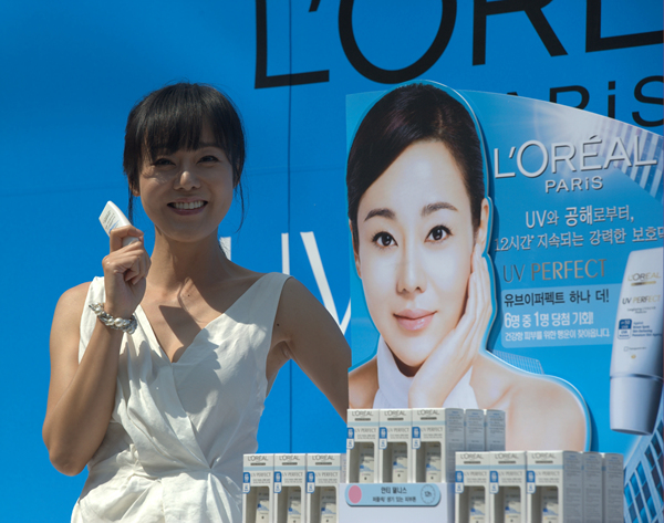 ▲ 월드스타 김윤진이 25일 오전 서울 소공동 롯데백화점 본점 야외광장에서 열린 유브이 퍼펙트 자외선차단제 아시아 판매 1500만개 돌파 행사에 참여, 유브이 퍼펙트 제품을 들고 포즈를 취하고 있다. ⓒ&nbsp;박지현 기자&nbsp;