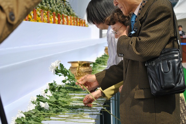 ▲ 한 시민이 숙연한 표정으로 헌화를 하고 있다. ⓒ 뉴데일리