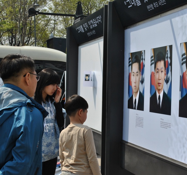 ▲ 순국장병의 생전 사진을 바라보던 한 여성이 눈시울을 붉히고 있다. ⓒ 뉴데일리