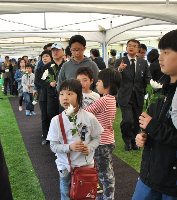▲ 국화꽃을 받고 자신의 헌화 순서를 기다리는 어린 조문객들. ⓒ 뉴데일리