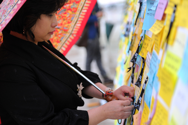 ▲ 한 여성 조문객이 순국장병들을 향한 메시지를 적은 뒤 정성스레 게시판에 붙이고 있다.&nbsp; ⓒ 김상엽 기자