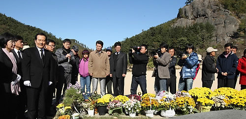 ▲ 민주당 정세균 대표와 이미경 사무총장, 재보선 당선자 및 출마자 등이 경남 김해시 진영읍 본산리 봉하마을 고 노무현 전 대통령 묘소를 참배한 뒤 묘역을 둘러보고 있는 모습. 멀리 뒤쪽에 노 전 대통령이 투신했던 부엉이바위가 보인다 ⓒ연합뉴스