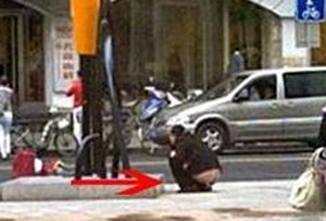 ▲ 중년 여성이 상하이 시내 한복판에서 바지를 내리고 엉덩이를 드러낸 채 소변을 보고 있다. ⓒ 온바오닷컴