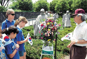 ▲ 미국 워싱턴DC 한국전 참전 기념관을 찾은 미국인들에게 현운종씨가 태극기를 나눠주며 미국이 6&middot;25전쟁에 참전한 데 대해 고마움을 전하고 있다. ⓒ 조선일보 제공