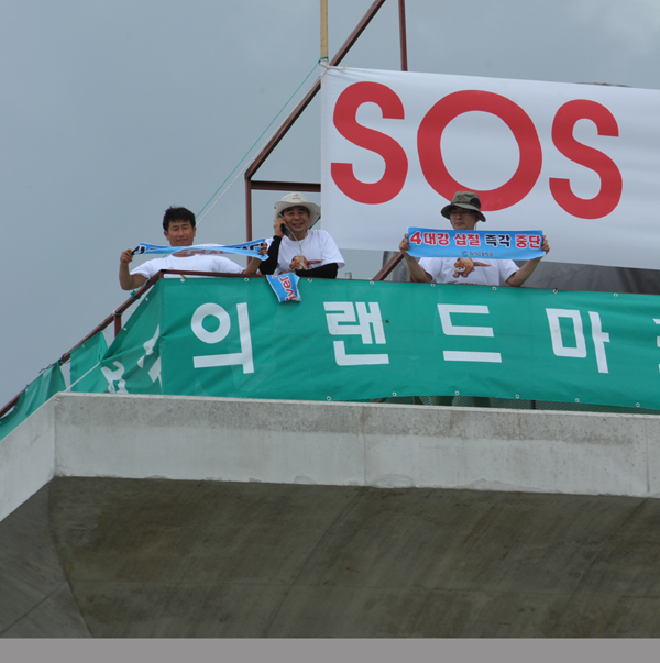 ▲ 이포보 점거농성자들이  휴대폰 통화를 하며 웃고 있다. ⓒ 뉴데일리