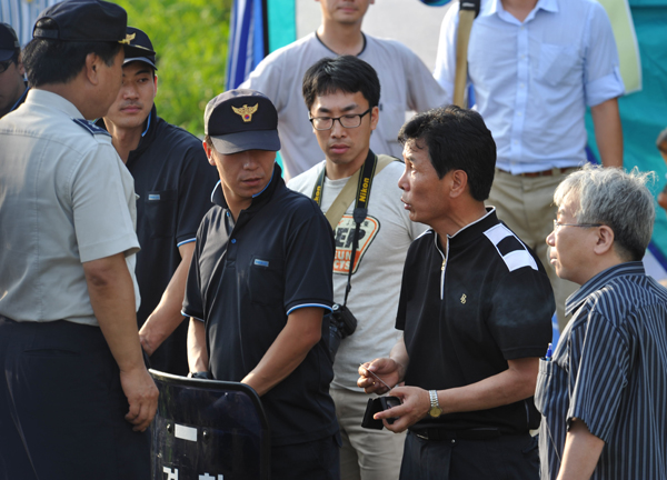 ▲ 유원일(검은색 티셔츠)의원이 자신을 보호하지 못했다며 경찰에게 항의하고 있다. ⓒ 뉴데일리