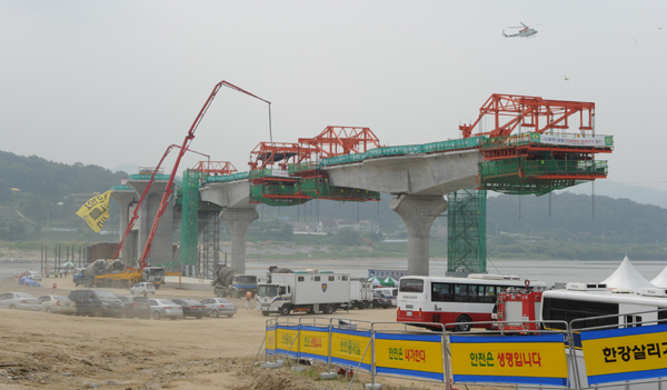 ▲ 어지러운 이포보 현장. 경찰차, 구급차, 컨테이너박스, 안전펜스 등으로 일부 진행되는 콘크리트 작업마저도 능률이 크게 떨어지고 있다. ⓒ 뉴데일리