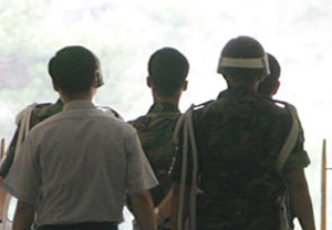 ▲ 530GP 총기난사사건의 피의자인 김동민(가운데)일병이 지난 2005년 6월 24일 국방위 진상조사단의 조사를 받은 뒤 헌병과 수사관의 호위 속에 차량으로 향하고 있다 ⓒ 연합뉴스
