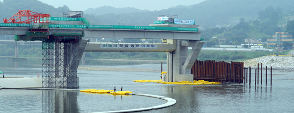 ▲ 불법 점거 상태인 이포보 구조물. 수문은 들려 있고, 강물은 물살이 세 안전튜브가 제자리를 잡지 못하고 몰려있다. 수문을 내리고 안전망을 설치하려해도 농성자들이 발전기 접근을 막고 있다. ⓒ 뉴데일리