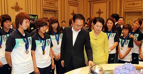 ▲ 이명박 대통령과 김윤옥 여사가 10일 청와대에서 열린 U20 여자월드컵 축구대표팀 초청 오찬에서 선수들과 함께 선수단이 받은 트로피와 상패를 살펴보고 있다. ⓒ연합뉴스