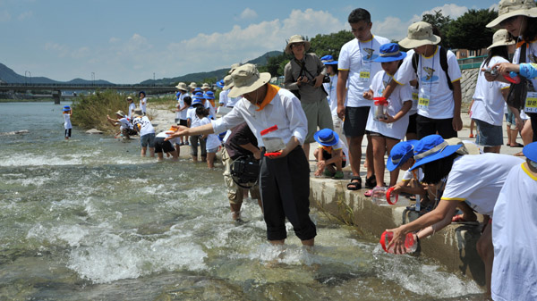 ▲ 국립수산과학원, 순천향대학교,무주군청 등이 참가한 치어방류행사 참가자들이 어린 어름치를 금강에 풀어주고 있다. ⓒ 뉴데일리
