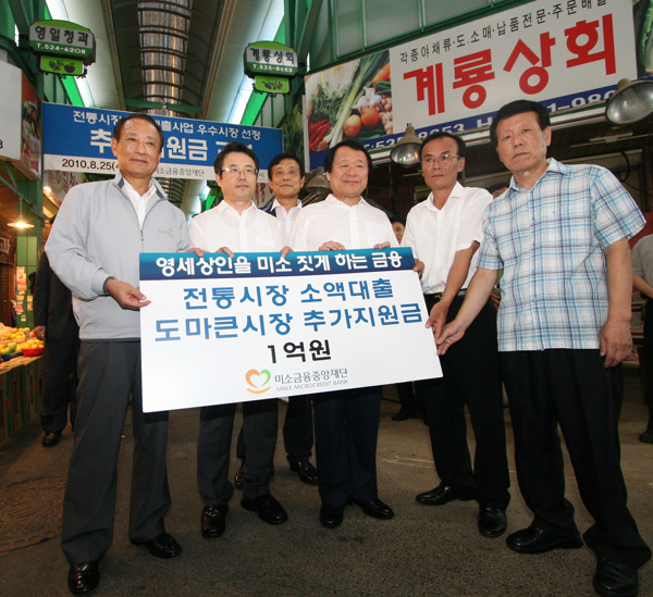 ▲ 미소금융중앙재단이 도마큰시장에 전통시장 소액대출 추가지원금 1억원을 전달하고 있다(왼쪽부터 미소금융중앙재단 김승유 이사장,금융위원회 권혁세 부위원장, 하나은행 김정태 은행장,염홍철 대전광역시장, 대전 도마큰시장 상인들) ⓒ 뉴데일리