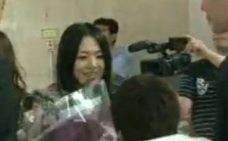 ▲ 아오이 소라의 귀국 장면을 담은 판도라TV 동영상 캡처. 아오이 소라에게 꽃다발을 안기는 달마시안 멤버의 뒷모습이 보인다. ⓒ 뉴데일리