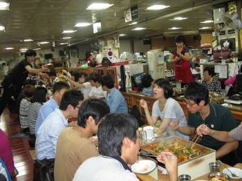 ▲ 시장 상인들과 식사를 하며 이야기꽃을 피우고 있는 대학생들.  ⓒ 뉴데일리